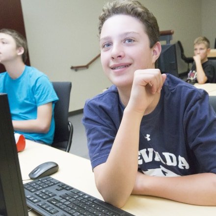 Kid in classroom using computer